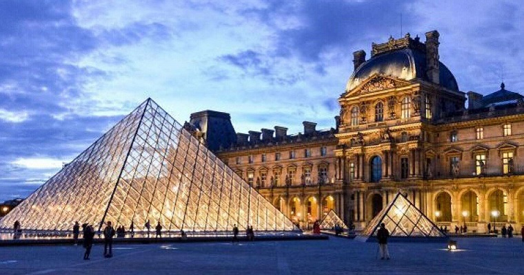 Fachada do Museu do Louvre. Palácio e Piramide de Vidro com as pessoas ao redor.